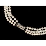 A TRIPLE STRAND CULTURED PEARL NECKLACE WITH DIAMOND SET CLASP, comprising three strands of
