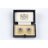 A PAIR OF SAPPHIRE AND DIAMOND EARSTUDS, each openwork millegrained panel centred with a trio of