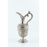 A VICTORIAN SILVER CLARET JUG, repoussé decorated with oval masks, flowers and stylised foliage,