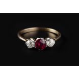 A RUBY AND DIAMOND THREE STONE RING, the circular mixed-cut ruby claw set between two old