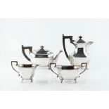 A SILVER FOUR PIECE TEA SERVICE, of elongated octagonal section with ebonised handles and knops,