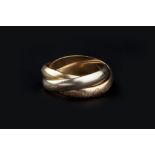 A 'TRINITY' RING BY LES MUST DE CARTIER, composed of three interlocking tri-coloured bands,