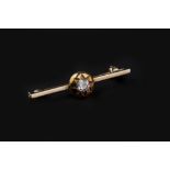 A DIAMOND SINGLE STONE BAR BROOCH, the cushion-shaped old-cut diamond in star-shaped setting,