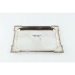 A SILVER RECTANGULAR TRAY, with projecting corners and beaded border, and with central repoussé