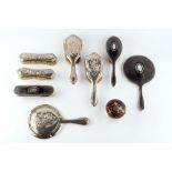 A SILVER AND TORTOISESHELL MOUNTED DRESSING TABLE SET, comprising hand mirror, hairbrush, clothes