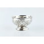 A LATE VICTORIAN SILVER SUGAR BASIN, of spirally half lobed pedestal form, repoussé decorated with