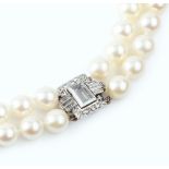 A CULTURED PEARL DOUBLE STRAND NECKLACE WITH DIAMOND CLASP, comprising two strands of uniform