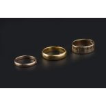 THREE WEDDING BANDS, comprising a 22ct gold wedding band, a 9ct gold wedding band, of engraved