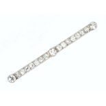 A DIAMOND BAR BROOCH, the uniform bar of transitional brilliant-cut diamonds spaced by three