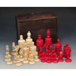 A VICTORIAN CARVED IVORY CHESS SET of turned form in wooden box, King 11.5cm high