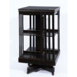 A LATE 19TH CENTURY STAINED WOOD SQUARE REVOLVING THREE TIER BOOKCASE with slatted sides, 47cm