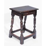 A 17TH CENTURY OAK RECTANGULAR JOINT STOOL on ring turned legs with stretcher supports, 45cm wide