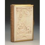 A MID VICTORIAN GILT METAL AND IVORY MOUNTED PRAYER BOOK, the cover with relief carved ivory, plaque