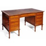 A LATE 19TH CENTURY SATINWOOD VENEERED WRITING DESK having a leather tooled top and concave front,