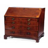 A GEORGE III FIGURED MAHOGANY BUREAU, the interior fitted with central compartment, pigeon holes and