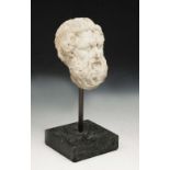 A GRAND TOUR STYLE CARVED MARBLE HEAD IN THE ROMAN STYLE of Hirsute male subject after the Antique