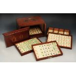 A CHINESE BONE MAH JONG SET contained within a painted wooden box fitted five drawers with