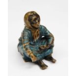 A VIENNA BERGMAN COLD CAST BRONZE SEATED FIGURE of a girl in blue tunic, signed, 7cm high