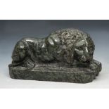 A GRAND TOUR STYLE CARVED SERPENTINE MODEL of a crouching lion on plinth, 15cm long