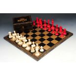 AN OLD IVORY CHESS SET contained within a black lacquered box with figure decoration, 15cm wide;