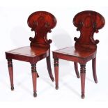 A PAIR OF EARLY 19TH CENTURY MAHOGANY HALL CHAIRS, the waisted backs with reeded borders, raised