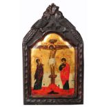 A 20TH CENTURY GREEK ICON painted the Crucifixion, oil on panel with carved cresting, 43 x 27cm (