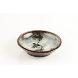 Margaret Frith (b.1943) Dish nuka and tenmoku glaze impressed potter's seal 23cm across.