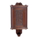 Manner of Yattendon School of Art Corner cupboard oak, the door carved with grape vines 112cm high.