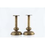 Manner of Newlyn School Pair of Arts & Crafts candlesticks brass, with twisted stems over embossed