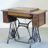 A 1920's oak cased Singer sewing machine, on a cast iron base,