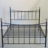 A black painted and brass double bedstead, with a metal slatted base,