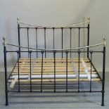 A black painted and brass king size bedstead, with a wooden slatted base,