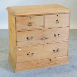 An antique pine chest of drawers, on a plinth base,