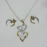 A 9 carat gold and white gold heart shaped necklace, on a silver chain,