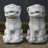 A pair of reconstituted stone models of dogs,