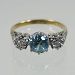 An 18 carat gold and platinum set diamond and topaz three stone ring,