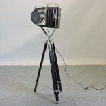 A chrome stage light, on an adjustable tripod base,