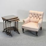 A Victorian pink upholstered armchair, together with a nest of occasional tables,