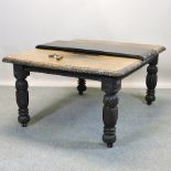 A 19th century carved oak wind-out dining table, with additional leaf and winder,