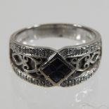 An 18 carat white gold sapphire ring, with a diamond set openwork surround,