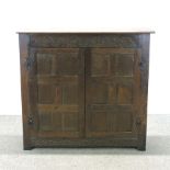 A 19th century dwarf carved oak cupboard, with panelled doors,