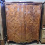 A continental marquetry inlaid serpentine wardrobe,