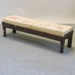 A 19th century carved oak long footstool, with animal print upholstery,