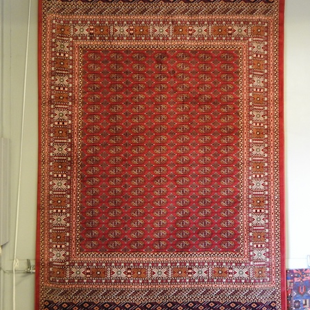 A Bokhara style carpet, on a red ground,