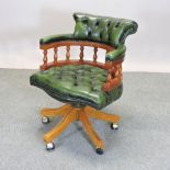 A reproduction yew wood and green leather upholstered button back desk chair