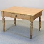An antique pine kitchen table, with a single drawer, on turned legs,