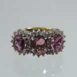 An 18 carat gold pink sapphire and diamond triple cluster ring, boxed,
