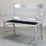 A silver painted and black upholstered bench,