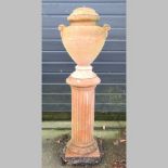 A terracotta urn, on a column pedestal,