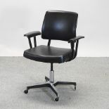 A 1970's black upholstered swivel desk chair